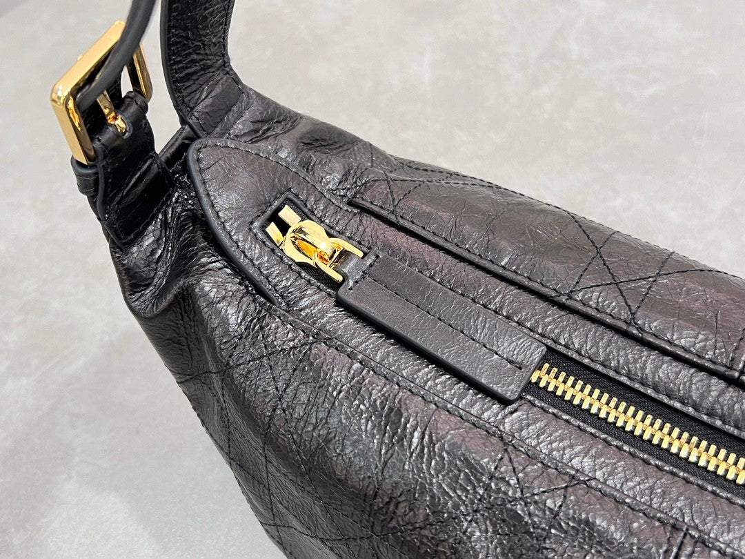 Distinctive black armpit bag, accentuated by metal accessories, a must - have for chic style.