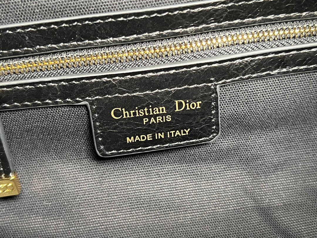 Distinctive black armpit bag, accentuated by metal accessories, a must - have for chic style.