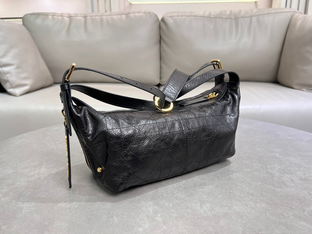 Distinctive black armpit bag, accentuated by metal accessories, a must - have for chic style.