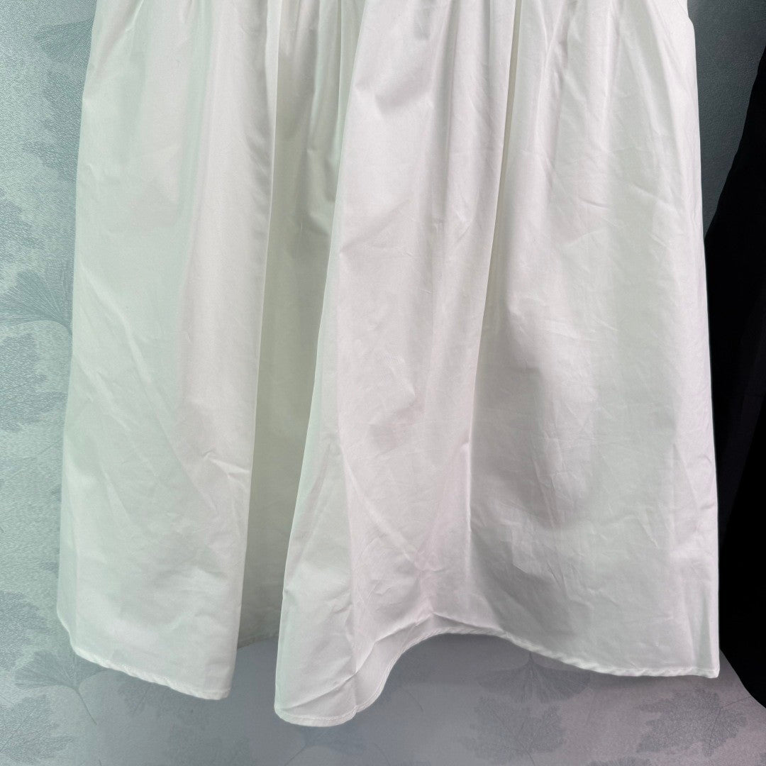 Dress with notched collar, small V - neck, ruffled sleeves and a cinched waist. Made of custom - sourced, pure cotton material.