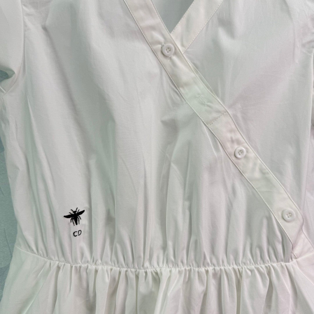 Dress with notched collar, small V - neck, ruffled sleeves and a cinched waist. Made of custom - sourced, pure cotton material.