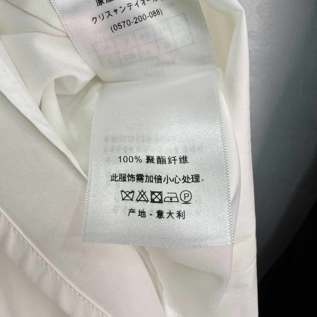 Dress with notched collar, small V - neck, ruffled sleeves and a cinched waist. Made of custom - sourced, pure cotton material.